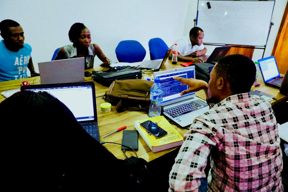 Developers working together at laptops in a shared office